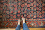 Vintage Heriz carpet's unusual allover boteh pattern on a navy blue ground with even wear.