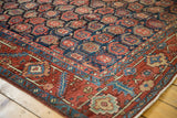 Corner of vintage Heriz rug, allover boteh motifs on navy field, rich brick red border.
