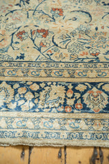 Vintage Tabriz rug border with faded blue, ivory, and rust scrolling tendrils and palmettes.