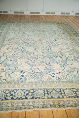Persian Tabriz carpet border with faded navy blue, ivory palmettes, tendrils, and fringe.