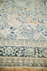 Vintage Tabriz carpet fringe and border, showing faded navy and ivory scrolling tendrils, terracotta palmettes.