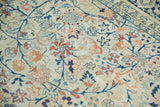 Detail of hand knotted vintage Tabriz rug, ivory field, faded navy tendrils, terracotta palmettes.