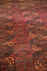 Vintage Ersari carpet's repeating Gul pattern in dark red, pale apricot, and navy.