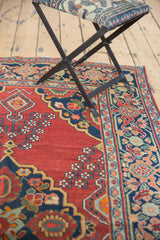 Vintage Trans-Caucasian rug: cherry red field, vase floral motifs, scalloped navy contour.