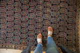 Antique Afshar rug displaying intricate staggered boteh design in navy, madder red, and pale gold tones.