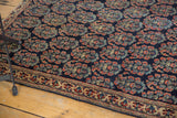 Intricately woven border of the antique Afshar rug, with red boteh motifs on a navy field.