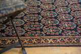 Intricate boteh motif and detailed border of an antique Afshar rug in navy, red, and gold.