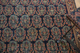 Finely woven boteh motifs with navy, madder red, and pale gold on an antique Afshar rug.