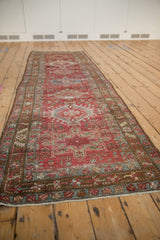 Distressed Karaja runner's wine red and dark teal geometric patterns, low pile, exposed foundation.