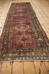 Distressed Karaja runner's low pile, revealing geometric patterns, knot heads, and foundation in burgundy and dark teal.