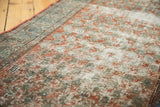 Worn texture of a vintage Serbend rug, revealing terracotta, sky blue, and ivory boteh.
