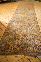 Distressed Malayer runner's end with low pile, fringed edge, and soft ivory, gold, and blush paisley.