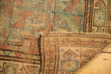 Distressed Ersari carpet with geometric motif, folded to show secured woven backing.