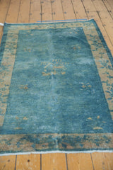 Distressed sky blue Peking rug section showing faded pile and antique ivory floral border.