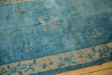 Distressed sky blue Peking rug with low pile, visible knot heads, and antique ivory floral border.