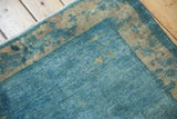 Distressed vintage Peking rug corner, low pile, visible knot heads, blues and ivory.