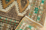 Corner detail of distressed Jaldar rug, geometric patterns, low pile, gold, sand, and bright green.