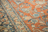 Vintage distressed Mahal carpet, soft rust field, blue floral sprays, traditional curvilinear design.
