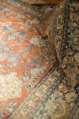 Distressed vintage Mahal carpet with pale rust and dark teal scrolling floral motifs.