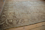Distressed vintage Heriz carpet corner, dark geometric border, low pile, exposed knot heads.