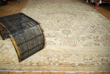 Distressed Heriz carpet featuring geometric serrated leaves and palmettes in ivory and gold.