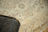 Intricate geometric patterns and time-softened tones on a vintage distressed Heriz carpet.