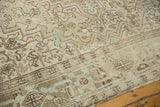 Distressed low pile displaying geometric leaves and palmettes in antique ivory and bronze tones.