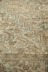 Distressed vintage Heriz carpet texture, geometric palmettes and leaves in ivory and bronze.