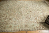 Distressed Heriz carpet detail: low pile, geometric pattern in ivory, bronze, pale green.