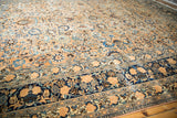 Distressed vintage Meshed carpet with beige floral field and a detailed dark blue lotus border.