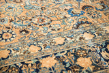 Distressed Meshed rug close-up: faded beige field, palmettes, sky blue florals, and patterned border.