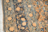 Distressed vintage Meshed carpet: intricate floral palmettes, navy border, beige field, and fringe.