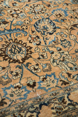 Distressed pile texture showing faint foundation, with blue floral palmettes on a beige field.