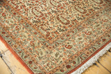 Fine weave Qom carpet corner: ivory field, rust paisley, and blue-green border.