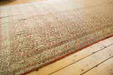 Corner detail of a vintage Qom carpet, showing rust, pale blue, and ivory patterned borders.