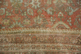 Detail of distressed Persian Mahal rug with faded floral patterns and exposed foundation.