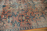 Distressed vintage Mahal carpet texture with brick red ground and teal scrolling floral details.