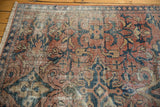 Distressed texture and natural fringe of vintage Mahal carpet in faded brick red, navy, sand.