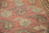Afghan rug runner, close-up of terracotta field with stylized olive boteh and geometric border.