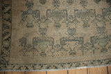 Vintage Afshar rug close-up: antique ivory field, powder blue planter motifs, serrated border, and fringe.