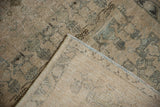 Vintage Afshar rug corner reveals worn pile, faint foundation showing through, and fringed edge.