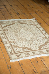 Corner detail of the vintage Bijar rug with scalloped floral border and ivory fringe.