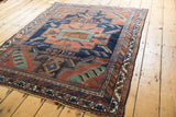 Stepped geometric patterns in terracotta, navy blue, and celadon on an antique Afshar rug.