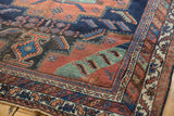 Geometric stepped patterns and border motifs in navy, terracotta, celadon on an antique Afshar.