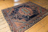 Antique Persian Afshar rug's secured end, geometric borders, navy field, and visible wear.