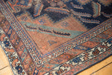 Antique Afshar rug corner displays geometric borders, navy, terracotta, and time-softened pile.