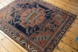 Secured side of an antique Afshar rug, revealing multi-band geometric border.