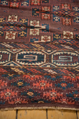 Close-up of the plum field and geometric guls near the secured end of the antique Turkmen rug.