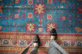 Khotan carpet's sapphire blue field with long-stemmed floral palmettes and a multi-hued border.