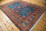 Corner of Khotan carpet: sapphire blue field, cherry red borders, and secure ivory fringe.